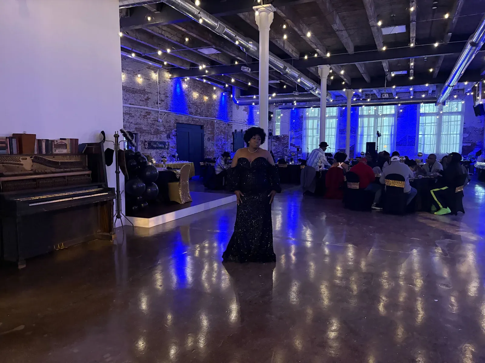 Guests seated at candlelit tables during an evening celebration in the Edison Room at 24 Shelby, a downtown Indianapolis venue for milestone birthday and graduation parties