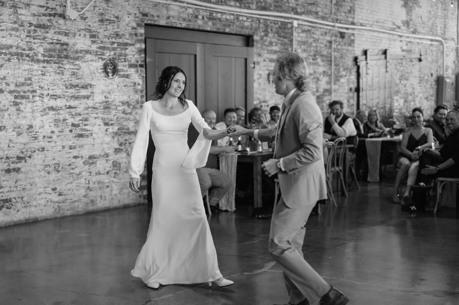 A first dance under Edison string lights at 24 Shelby, the warm glow and exposed brick of a historic 1920s wedding venue in downtown Indianapolis