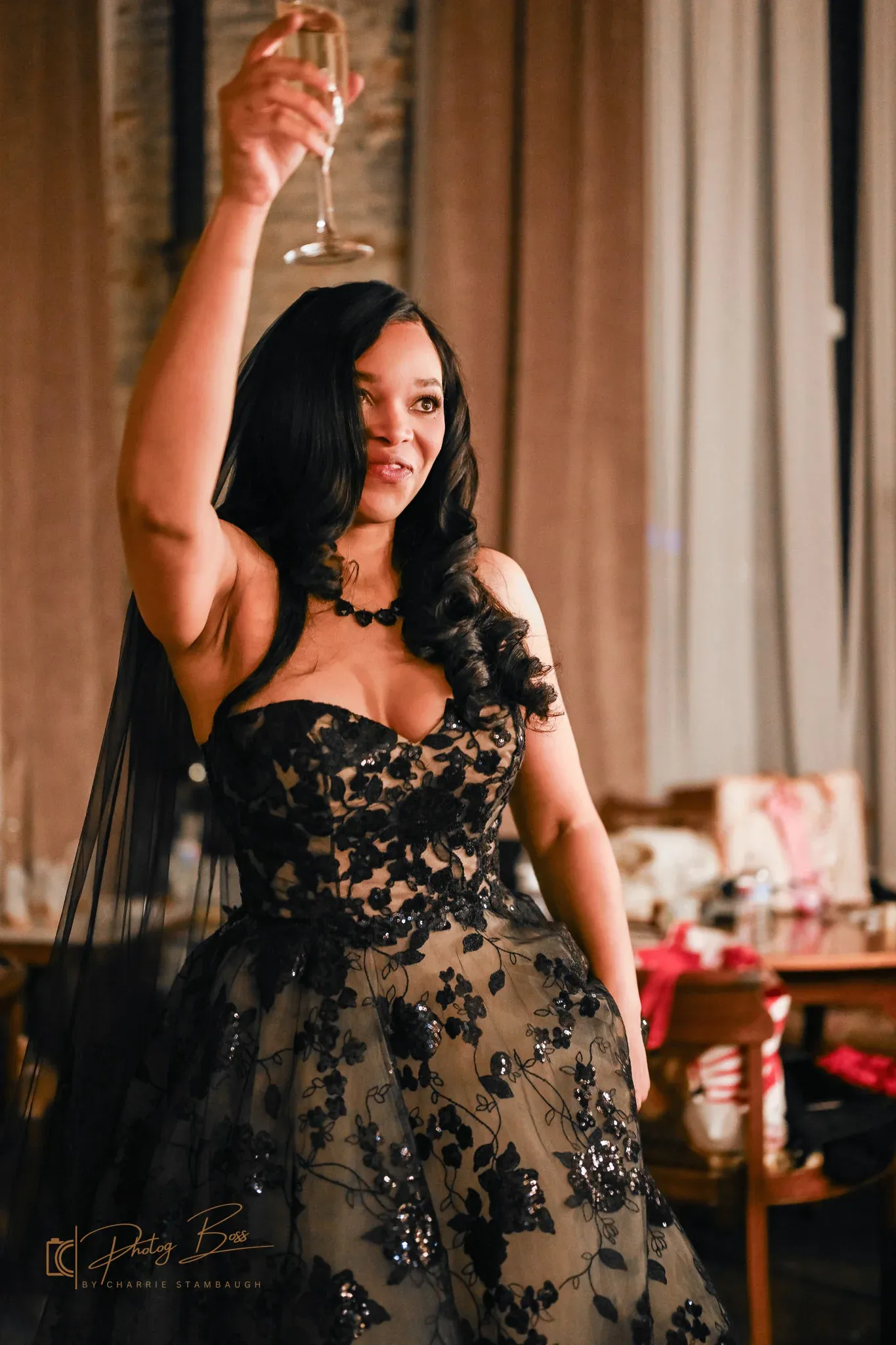 A guest in a 1920s-style sequined gown raising a champagne glass in a toast at a milestone birthday party in downtown Indianapolis