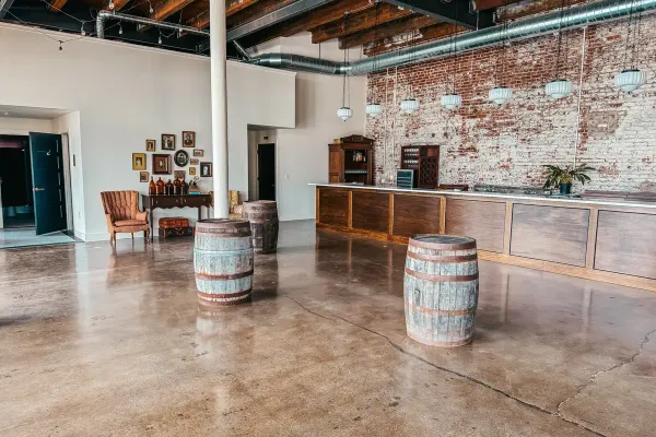 Libations Lounge at 24 Shelby in downtown Indianapolis set for an intimate micro wedding reception, with the fully stocked bar, warm Edison lighting, original 1898 brick walls, and seating arranged for fewer than 50 guests.