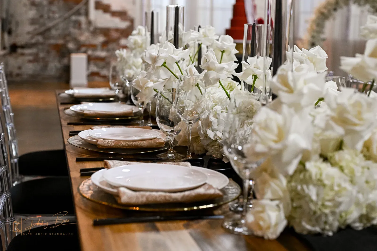A reception tablescape at 24 Shelby with candlelight, geometric place settings, and florals against the original 1898 brick, styled for an Art Deco wedding in Indianapolis