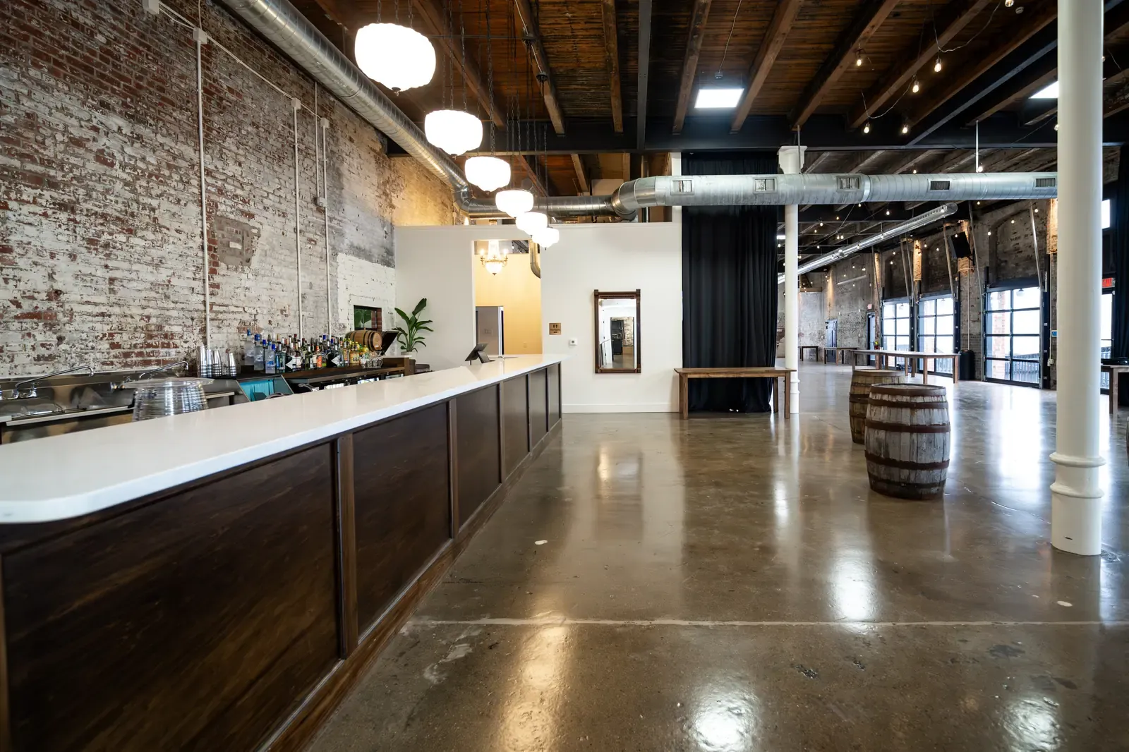 Bartender preparing cocktails at the in-house bar inside 24 Shelby, where bar service is part of the rental instead of a separate wedding venue fee.