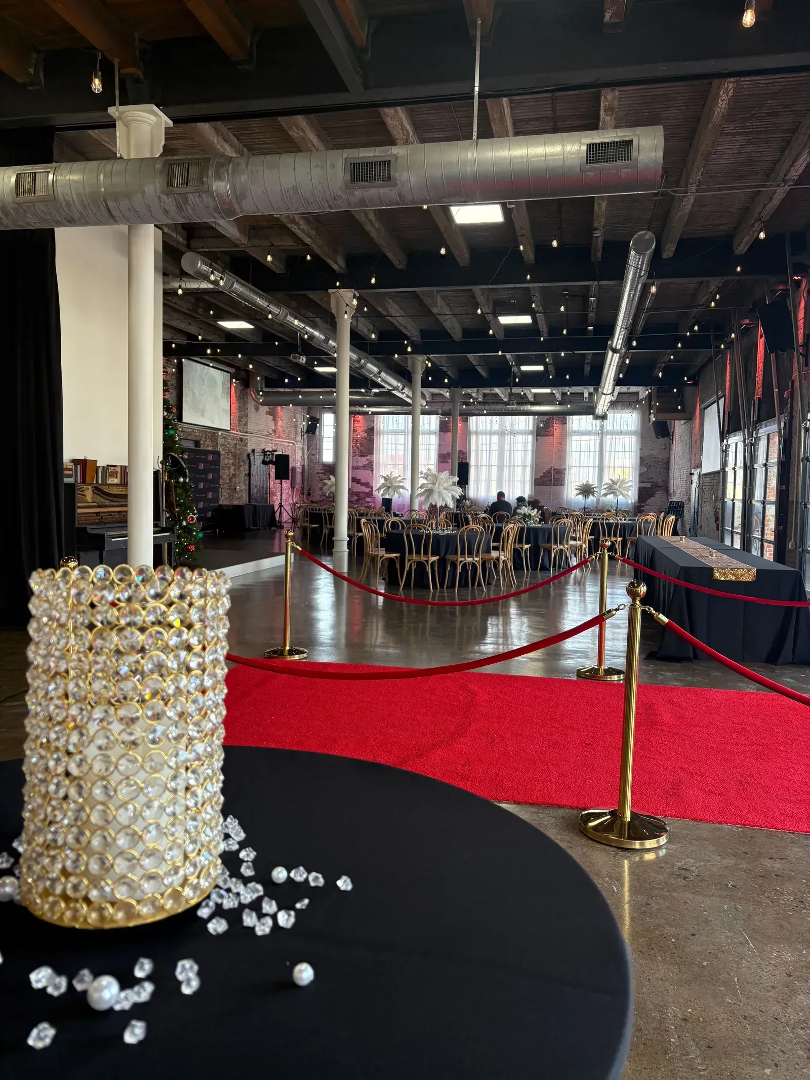 Guests arriving at a festive corporate holiday party at 24 Shelby in downtown Indianapolis with warm lighting and a red carpet entrance