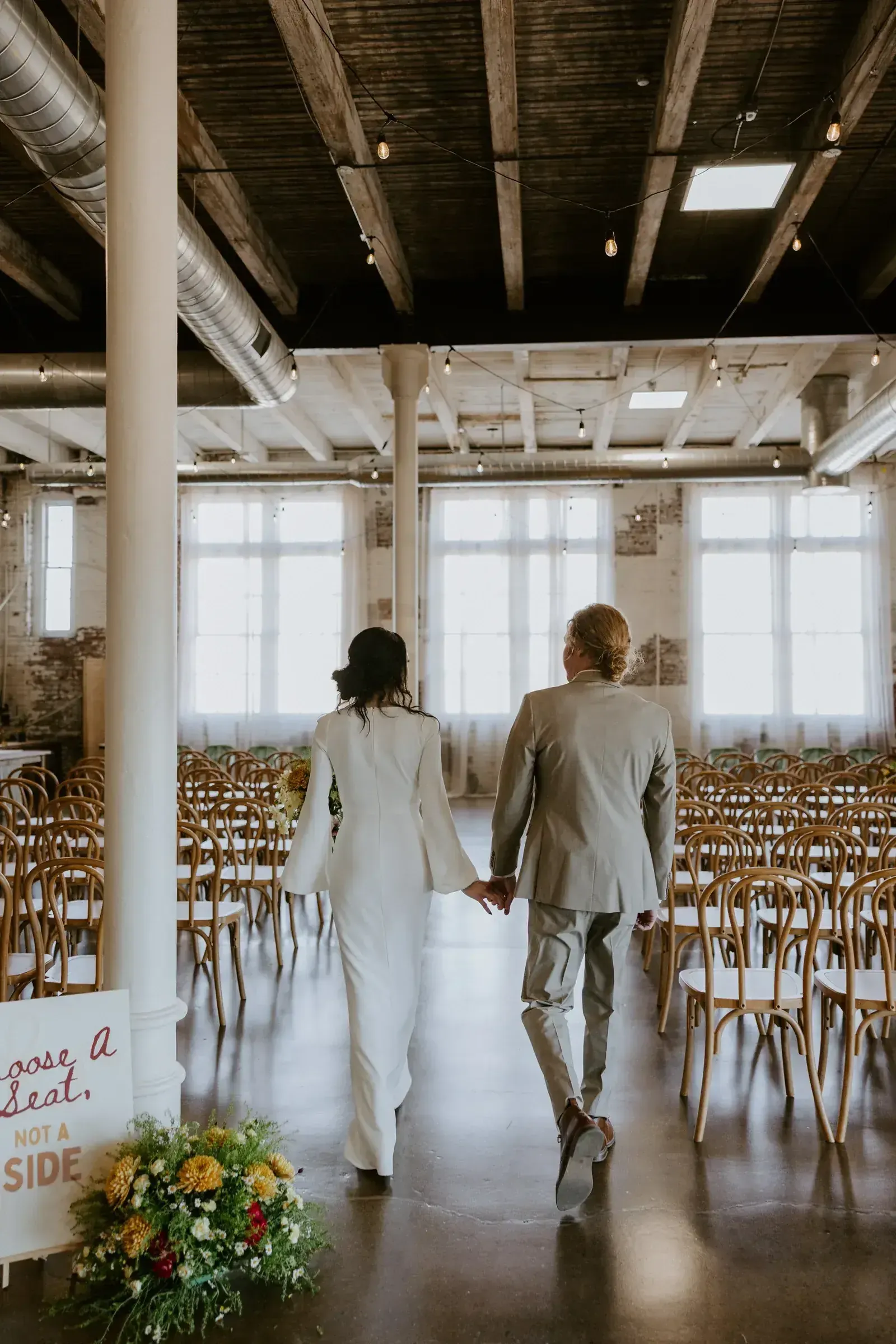 Featured couple portrait inside an affordable downtown Indianapolis wedding venue, with the venue's built-in 1898 brick walls and warm Edison string lights doing the work of the decor.
